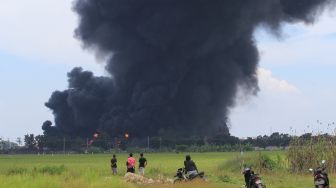 Warga melihat kepulan asap hitam akibat kebakaran tangki minyak milik Pertamina RU VI Balongan, Indramayu, Jawa Barat, Senin (29/3/2021). ANTARA FOTO/Dedhez Anggara