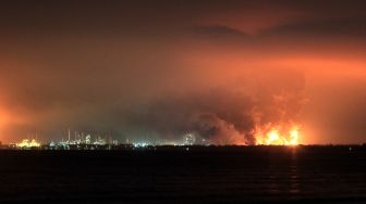 Warga mengambil video dengan gawai miliknya saat terjadi kebakaran di kompleks Pertamina RU VI Balongan, Indramayu, Jawa Barat, Senin (29/3/2021) dini hari. ANTARA FOTO/Dedhez Anggara