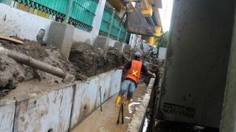 Pekerja menyelesaikan penataan kawasan Stasiun Gondangdia di Jakarta, Senin (29/3).  [Suara.com/Dian Latifah]