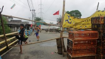 Anak-anak bermain layangan diatas jembatan graha Prima Kali jambe di tambun selatan, Kabupaten Bekasi (30/03/21). [Suara.com/Dian Latifah]