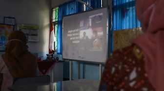 Guru dan Orang Tua murid melaksanakan simulasi sekolah tatap muka Hybrid di SMP Negeri 255, Jakarta Timur, Selasa (30/3/2021). [Suara.com/Alfian Winanto]