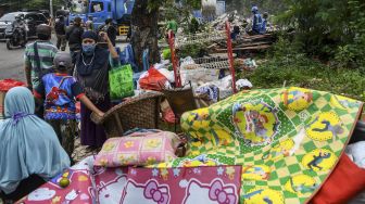 Warga berdiri di dekat perabot miliknya usai penertiban bangunan di kawasan Menteng Dalam, Tebet, Jakarta Selatan, Selasa (30/3/2021). ANTARA FOTO/M Risyal Hidayat