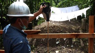 Ahli geologi mengambil foto tumpukan tanah makam yang meninggi di Nagari Sungai Asam, Kecamatan 2 x 11 Enam Lingkung, Padang Pariaman, Sumatera Barat, Senin (29/3/2021). ANTARA FOTO/Muhammad Arif Pribadi