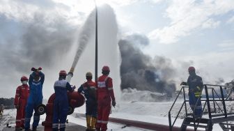 Tim HSSE & Fire Fighter Pertamina berupaya memadamkan api di lokasi insiden terbakarnya tangki penyimpan BBM di Kilang Balongan RU VI, Indramayu, Jawa Barat, Rabu (31/3/2021). [ANTARA FOTO]