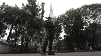 Personel TNI berjaga di depan Gereja Katedral, Jakarta, Kamis (1/4/2021). [Suara.com/Angga Budhiyanto]