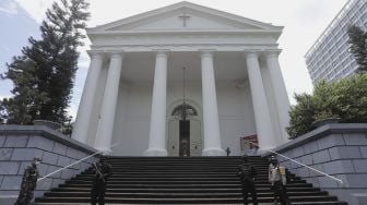 Petugas kepolisian berjaga saat melakukan pengamanan dan sterilisasi di sela berlangsungnya misa Jumat Agung menjelang hari raya Paskah di Gereja Immanuel, Jakarta, Jumat (2/4/2021). [Suara.com/Angga Budhiyanto]