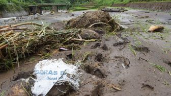 Warga melihat area sawah yang rusak akibat banjir di Desa Cermo, Kare, Kabupaten Madiun, Jawa Timur, Jumat (2/4/2021). ANTARA FOTO/Siswowidodo