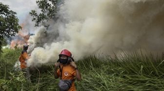 Satgas Kebakaran Hutan dan Lahan (Karhutla) Riau yang terdiri dari petugas Manggala Agni Daops Pekanbaru, BPBD Pekanbaru, Masyarakat Peduli Api dan TNI Polri berusaha memadamkan api yang membakar lahan ketika terjadi kebakaran lahan di Pekanbaru, Riau, Jumat (2/4/2021). [ANTARA FOTO/Rony Muharrman]