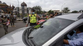 Petugas gabungan Satgas COVID-19 melakukan pemeriksaan surat keterangan tes cepat Antigen kepada wisatawan di jalur wisata Puncak, Gadog, Kabupaten Bogor, Jawa Barat, Jumat (2/4/2021).  ANTARA FOTO/Yulius Satria Wijaya