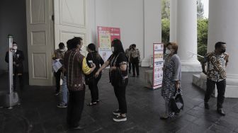 Petugas memeriksa suhu tubuh jemaat yang akan mengikuti ibadah misa Jumat Agung rangkaian hari raya Paskah di Gereja Immanuel, Jakarta, Jumat (2/4/2021). [Suara.com/Angga Budhiyanto]