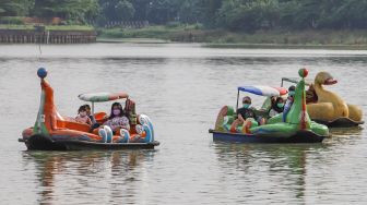 Warga menaiki wahana air saat berwisata di Perkampungan Budaya Betawi Setu Babakan, Jakarta Selatan, Minggu (4/4/2021). [Suara.com/Alfian Winanto]