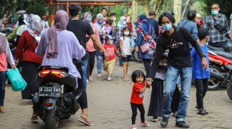 Warga berwisata di Perkampungan Budaya Betawi Setu Babakan, Jakarta Selatan, Minggu (4/4/2021). [Suara.com/Alfian Winanto]