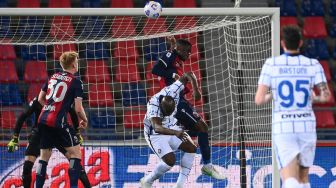 Penyerang Inter Milan Romelu Lukaku dan bek Bologna Bakary Adama Soumaoro melakukan sundulan selama pertandingan sepak bola Serie A Italia Bologna melawan Inter Milan di Renato Dall'Ara, Minggu (4/4/2021) dini hari WIB. Vincenzo PINTO / AFP
