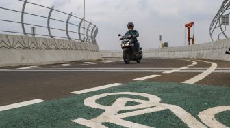 Warga membawa kendaraannya melewati Flyover Lenteng Agung di Jakarta Selatan, Minggu (4/4/2021). [Suara.com/Alfian Winanto]