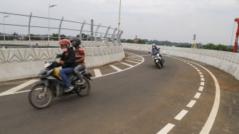 Warga membawa kendaraannya melewati Flyover Lenteng Agung di Jakarta Selatan, Minggu (4/4/2021). [Suara.com/Alfian Winanto]