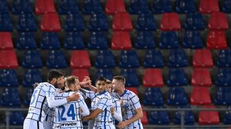 Para pemain Inter Milan merayakannya gol setelah Lukaku membuka skor selama pertandingan sepak bola Serie A Italia Bologna melawan Inter Milan di Renato Dall'Ara, Minggu (4/4/2021) dini hari WIB. [Vincenzo PINTO / AFP]

