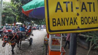 Warga berwisata di Perkampungan Budaya Betawi Setu Babakan, Jakarta Selatan, Minggu (4/4/2021). [Suara.com/Alfian Winanto]