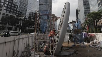 Pekerja menyelesaikan pembangunan Tugu Sepeda di Jalan Jenderal Sudirman, Jakarta, Senin (5/4/2021). [Suara.com/Angga Budhiyanto]