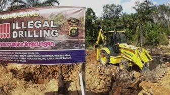 Petugas mengoperasikan alat berat untuk menutup sumur minyak ilegal yang ditinggalkan pemiliknya saat penertiban di Taman Hutan Raya Sultan Thaha Syaifuddin, Batanghari, Jambi, Senin (5/4/2021). [ANTARA FOTO/Wahdi Septiawan]