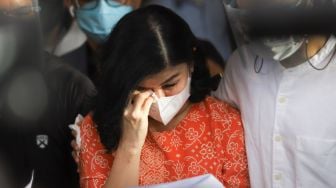 Istri Pengacara Hotma Sitompul, Desiree Tarigan menghapus air matanya saat memberi pernyataan ke awak media usai melaporkan suaminya dengan dugaan pencemaran nama baik di Polres Metro Jakarta Selatan, Rabu (7/4/2021). [Suara.com/Alfian Winanto]