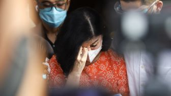 Istri Pengacara Hotma Sitompul, Desiree Tarigan menghapus air matanya saat memberi pernyataan ke awak media usai melaporkan suaminya dengan dugaan pencemaran nama baik di Polres Metro Jakarta Selatan, Rabu (7/4/2021). [Suara.com/Alfian Winanto]