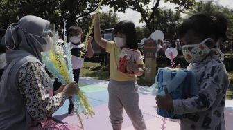 Sejumlah siswa taman kanak-kanak (TK) menunjukkan miniatur beduk buatannya saat mengikuti proses pembelajaran secara Drive in Learning (DRIL) di area parkir Padepokan Pencak Silat Indonesia, Jakarta, Kamis (8/4/2021). [Suara.com/Angga Budhiyanto]