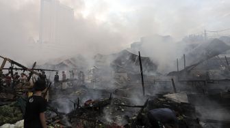 Warga menyaksikan kebakaran yang melanda Pasar Lontar atau Pasar Kambing di Jalan Sabeni, Tanah Abang, Jakarta, Kamis (8/4/2021). [Suara.com/Angga Budhiyanto]