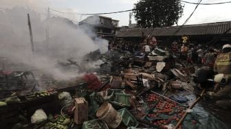 Warga menyaksikan kebakaran yang melanda Pasar Lontar atau Pasar Kambing di Jalan Sabeni, Tanah Abang, Jakarta, Kamis (8/4/2021). [Suara.com/Angga Budhiyanto]