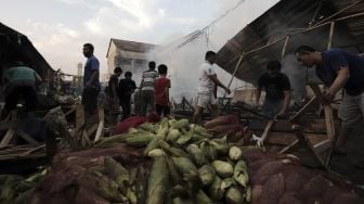 Warga menyelamatkan barang dagangannya dari kebakaran yang melanda Pasar Lontar atau Pasar Kambing di Jalan Sabeni, Tanah Abang, Jakarta, Kamis (8/4/2021). [Suara.com/Angga Budhiyanto]