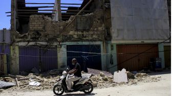 Seorang pengendara bermotor melintas di depan salah satu gedung yang ambruk akibat badai Siklon tropis Seroja di Kota Kupang, NTT, Kamis (8/4/2021). [ANTARA FOTO/Kornelis Kaha]