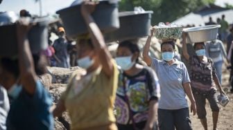 Sejumlah warga berjalan saat sebelum Presiden Joko Widodo akan meninjau lokasi tanah longsor di Desa Nelelamadike, Ile Boleng, Kabupaten Flores Timur, Nusa Tenggara Timur (NTT), Jumat (9/4/2021). [ANTARA FOTO/Aditya Pradana Putra]