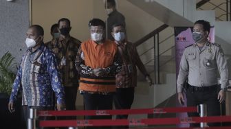 Bupati Bandung Barat Aa Umbara Sutisna (tengah) berjalan keluar usai menjalani pemeriksaan di Gedung Merah Putih KPK, Jakarta, Jumat (9/4/2021). [Suara.com/Angga Budhiyanto]