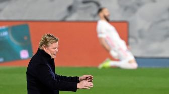 Ekspresi pelatih Barcelona Ronald Koeman saat melihat penyerang Real Madrid Karim Benzema melakukan selebrasi setelah mencetak gol selama pertandingan sepak bola Liga Spanyol antara Real Madrid melawan Barcelona di Stadion Alfredo di Stefano, Madrid, Sabtu waktu setempat atau Minggu (11/4/2021) dini hari WIB. JAVIER SORIANO / AFP
