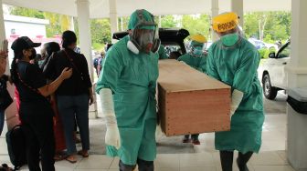 Jenazah guru SMP 1 Boega Yonathan Randen yang meninggal akibat ditembak oleh kelompok kriminal bersenjata (KKB) tiba di kamar jenazah RSUD Mimika, Papua, Sabtu (10/4/2021). ANTARA FOTO / Sevianto Pakiding