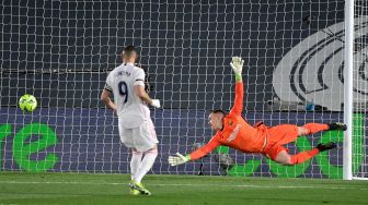 Penjaga gawang Barcelona Marc-Andre ter Stegen mencoba menepis bola tendangan penyerang Real Madrid Karim Benzema selama pertandingan sepak bola Liga Spanyol antara Real Madrid melawan Barcelona di Stadion Alfredo di Stefano, Madrid, Sabtu waktu setempat atau Minggu (11/4/2021) dini hari WIB. JAVIER SORIANO / AFP