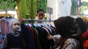 Pembeli memilih baju di Pasar Tanah Abang, Jakarta Pusat, Senin (12/4/2021). [Suara.com/Dian Latifah]