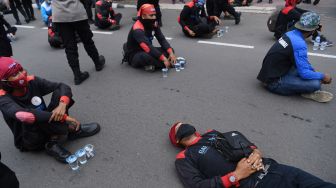 Sejumlah buruh yang tergabung dalam Konfederasi Serikat Pekerja Indonesia (KSPI) berunjuk rasa di kawasan Patung Kuda, Jakarta, Senin (12/4/2021). ANTARA FOTO/Hafidz Mubarak 