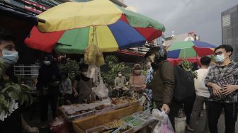 Pedagang melayani pembeli takjil dan makanan berbuka puasa di Pasar Takjil Benhil, Jakarta, Selasa (13/4/2021). [Suara.com/Angga Budhiyanto]