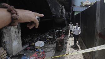 Warga mengecek sisa-sisa kebakaran di Pasar Minggu, Jakarta, Selasa (13/4/2021). [Suara.com/Angga Budhiyanto]