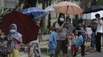 Sejumlah warga mengantre untuk mendapatkan takjil gratis di jalan Cempaka Putih Tengah XXI, Jakarta, Kamis (15/4/2021). [Suara.com/Angga Budhiyanto]