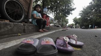 Seorang anak mengantre untuk mendapatkan takjil gratis di jalan Cempaka Putih Tengah XXI, Jakarta, Kamis (15/4/2021). [Suara.com/Angga Budhiyanto]