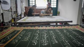 Perajin menyelesaikan pembuatan batik motif ayat Al Quran di Mahkota Batik Laweyan, Solo, Jawa Tengah, Jumat (16/4/2020). ANTARA FOTO/Mohammad Ayudha