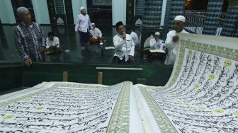 Umat Islam bertadarus menggunakan Al Quran raksasa di Masjid Baiturrahman, Banyuwangi, Jawa Timur, Jumat (16/4/2021).  ANTARA FOTO/Budi Candra Setya