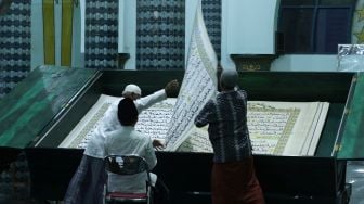 Umat Islam bertadarus menggunakan Al Quran raksasa di Masjid Baiturrahman, Banyuwangi, Jawa Timur, Jumat (16/4/2021).  ANTARA FOTO/Budi Candra Setya