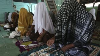 Jamaah suluk menutupi kepalanya dengan selendang dan surban saat mengikuti zikir di Pondok Pesantren Nurul Huda, Desa Reusak, Samatiga, Aceh Barat, Aceh, Sabtu (17/4/2021). [ANTARA FOTO/Syifa Yulinnas]