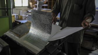 Pekerja mencetak kertas menggunakan mesin cetak huruf braile merk Thomson tahun 1952 untuk saat produksi Al Quran Braile di Percetakan Yayasan Penyantun Wyata Guna, Bandung, Jawa Barat, Sabtu (17/4/2021). [ANTARA FOTO/Raisan Al Farisi]