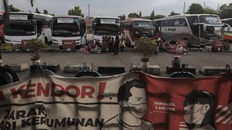 Sejumlah bus antar kota antar provinsi (AKAP) terparkir menunggu penumpang di Terminal Kampung Rambutan, Jakarta, Selasa (20/4/2021). [Suara.com/Angga Budhiyanto]