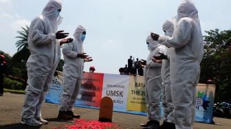 Aksi teatrikal yang dilakukan pendemo di depan Monas, Jakarta Pusat, Rabu (21/4/2021). [Suara.com/Dian Latifah] 