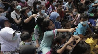 Ekspresi sejumlah anak korban kebakaran saat dihibur oleh Anggota komunitas Aku Badut Indonesia (ABI) di Keagungan, Taman Sari, Jakarta, Kamis (22/4/2021). [Suara.com/Angga Budhiyanto]