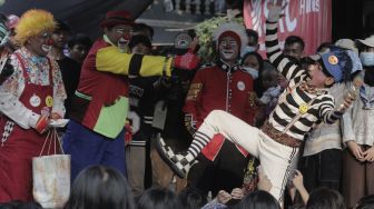 Anggota komunitas Aku Badut Indonesia (ABI) menghibur anak-anak korban kebakaran di Keagungan, Taman Sari, Jakarta, Kamis (22/4/2021). [Suara.com/Angga Budhiyanto]